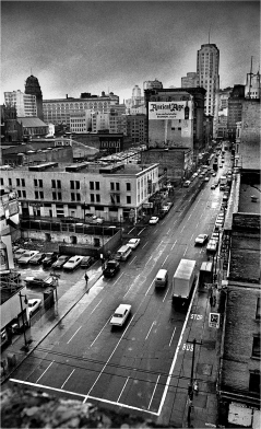 This is a view of Third and Howard St. from the Yerba Buena Hotel. Since the 1930s, this area was known as Skid Row. There were many hotels in the area catering to mostly single and transient men working as merchant marine sailors, shipyard and dockworkers. By the 1960s, many of the hotels had become slumlord operations catering to retired single male pensioners.