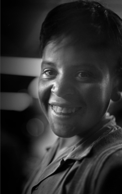 #1017-J-004 Mexico December 1970 Smiling Boy At the game arcades at night, no girls were present. In the Mexican culture, boys are given a lot more freedom than girls.